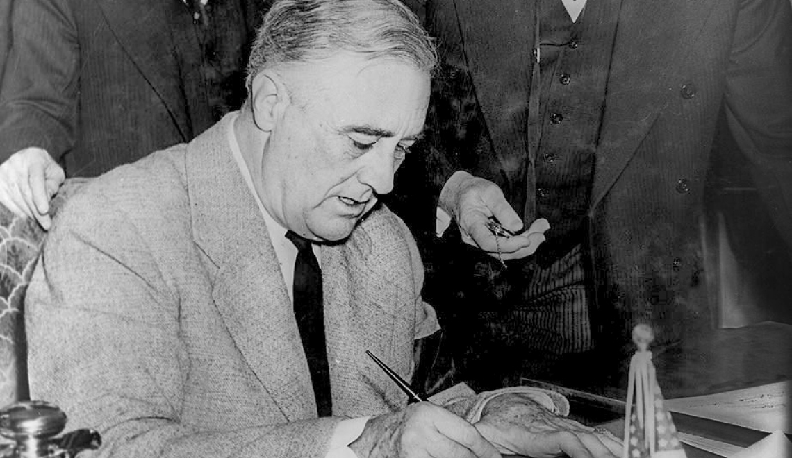 Franklin Roosevelt signing declaration of war against Germany - Wikimedia Commons - Farm Security Administration/Office of War Information Abbildung des US President Franklin D. Roosevelt beim unterzeichnen des Dokuments zum Eintritt in den Zweiten Weltkrieg