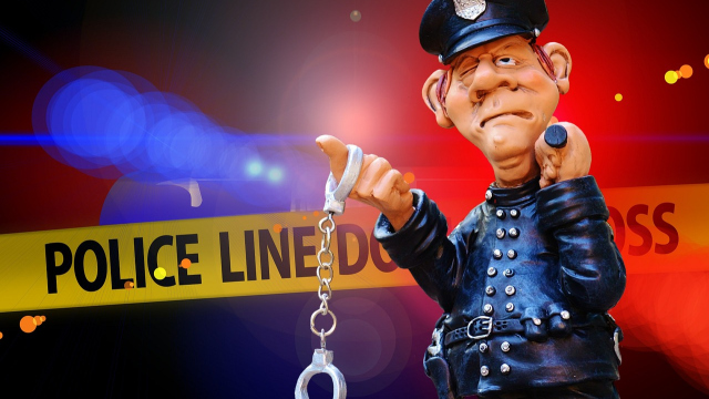 Abbildung einer Wachsfigur eines Polizisten vor einer Tatortabsperrung