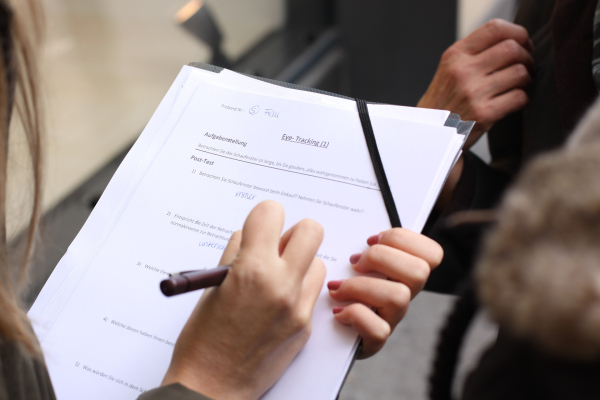 Abbildung von Haenden und einem Stift auf einem Ausfuellbogen Papier