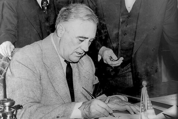 Abbildung des US President Franklin D. Roosevelt beim unterzeichnen des Dokuments zum Eintritt in den Zweiten Weltkrieg