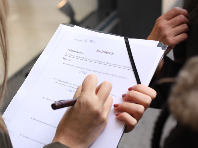 Abbildung von Haenden und einem Stift auf einem Ausfuellbogen Papier